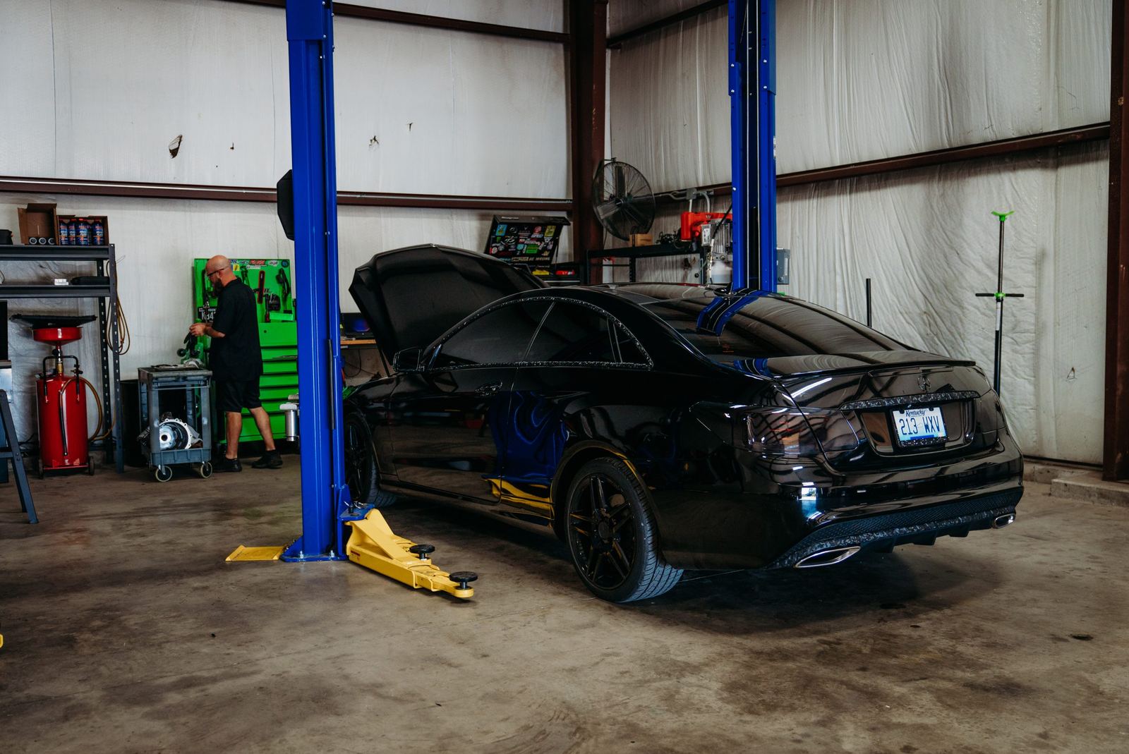A Mercedes on the lift inside the S Squared Automotive shop
